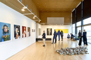 Ausstellungsbesucher:innen stehen vor Exponaten bei der STAGE Bregenz 2024 im Seefoyer im Festspielhaus