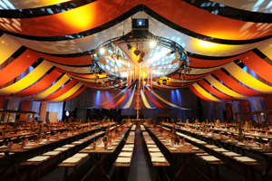 Lange eingedeckte Tischreihen in der festlich und bunt geschmückten Werkstattbühne des Festspielhauses Bregenz