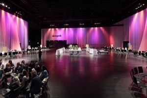 Workshopteilnehmer:innen an runden Stuhlkreisen in der pink eingeleuchteten Werkstattbühne des Festspielhauses Bregenz