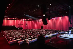 Werkstattbühne Parlamentbetischung, rot eingeleuchtete lange Vorhänge beim Wirtschaftsforum im Festspielhaus Bregenz © Anja Koehler