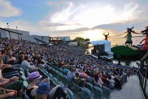 Vollbesetzte Seetribüne bei einem Pop-Konzert vor der Seebühne mit Sonnenuntergang