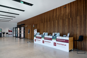 Registrierungscounter vor der dunklen Holzwand im Foyer Werkstattbühne