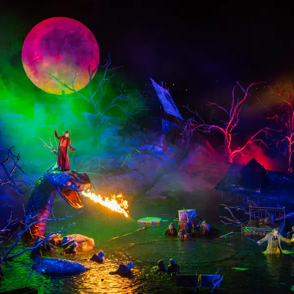 © Bregenzer Festspiele / Daniel Ammann bunt beleuchtetes Bühnenbild, ein Sänger steht auf einer feuerspeienden Schlange auf der Festspielbühne Bregenz © Bregenzer Festspiele / Daniel Ammann