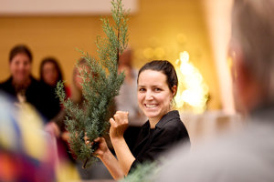 Eine fröhliche Frau mit einem Tannenzweig in der Hand