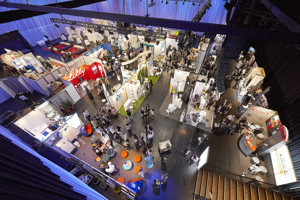 Gutbesuchte Ausstellungskojen auf der blau eingeleuchteten Werkstattbühne im Festspielhaus Bregenz