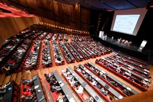 Vollbesetzter Großer Saal mit Parlamentbetischung und großer Leinwand und Podium auf der Vorbühne im Festspielhaus Bregenz © Matthias Rhomberg, LpS & TiL