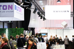 Tagungsteilnehmer:innen am Registrierungstresen auf der Seitenbühne im Festspielhaus Bregenz