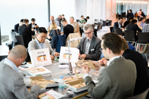 Kongressteilnehmer:innen sitzen in Gruppen an Tischen und bauen etwas zusammen im Parkstudio im Festspielhaus Bregenz