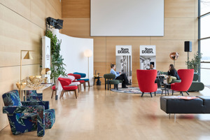 hoher Raum aus hellem Holz mit bunten Ohrensesseln