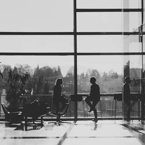 zwei Personen unterhalten sich an einem Stehtisch vor einer großen Glasfront im Festspielhaus © Büro Magma, Magdalena Türtscher