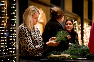 Eine Frau bindet konzentriert einen Adventkranz