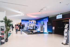 Kongressteilnehmer:innen bewegen sich durch eine Fachausstellung im Foyer des Festspielhauses