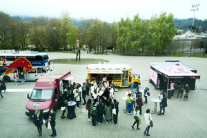 Menschen vor Foodtrucks und an Stehtischen auf dem Platz der Wiener Symphoniker