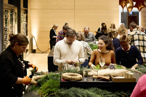Mehrere Personen binden Adventkränze im hellerleuchteten Seefoyer des Festspielhauses