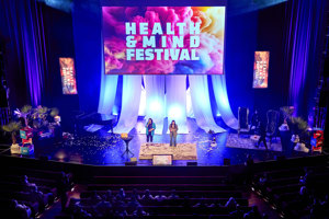 Zwei Moderatorinnen vor einer großen Leinwand beim Health & Mind Festival im Großer Saal im Festspielhaus Bregenz