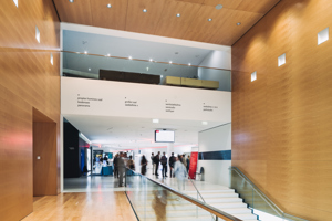 Kongressteilnehmer:innen bewegen sich über die Hauptstiege hinauf ins weiße Foyer des Festspielhauses