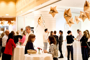 Advent-Hock Teilnehmer:innen unterhalten sich an Stehtischen