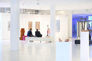 Ausstellungsbesucher:innen sitzen auf einem weißen Sofa im Foyer des Festspielhauses Bregenz