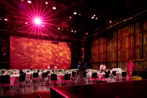 runde eingedeckte Tische mit weißen Tischdecken und schwarzen Stühlen auf der Hauptbühne im Festspielhaus