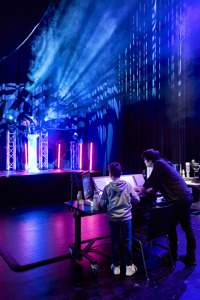 Ein Veranstaltungstechniklehrling zeigt einem Kind ein Mischpult im Festspielhaus Bregenz