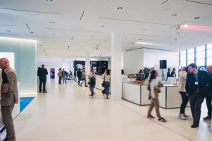 Kongressteilnehmer:innen im Pausenbewirtungsbereich im weißen Foyer des Festspielhauses