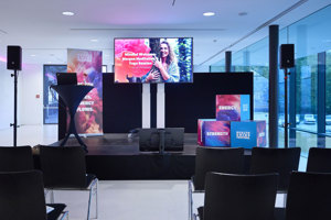 Ein Bühne mit Stehtisch und Großbildschirm beim Health & Mind Festival im weißen Parkstudio im Festspielhaus Bregenz