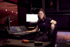Veranstaltungstechnik-Lehrling Fiona sitzt vor einem Mischpult und einem Screen