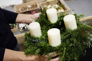 Ein Adventkranz mit vier weißen großen Kerzen