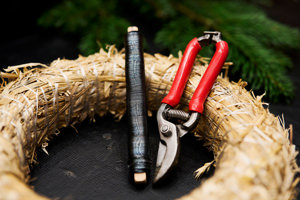 Adventkranz-Rohling mit Draht und Gartenschere auf einem Tisch