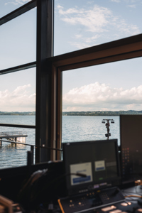 Ein Technikpult vor der großen Fensterfront im Seefoyer des Festspielhauses Bregenz mit Blick über den See