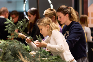 Mehrere Personen beim Adventkranzbinden im Seefoyer des Festspielhauses Bregenz