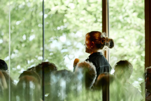 Eine Frau mit Mikrofon steht vor der Glasfront im Seestudio  des Festspielhauses Bregenz