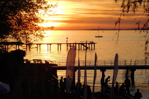 Sonnenuntergang über dem Bodensee mit Blick über den Schiffsanlegesteg des Festspielhauses Bregenz