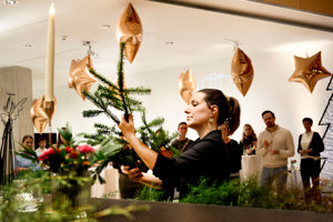 Eine Frau zeigt den Teilnehmer:innen beim Advent-Hock im Festspielhaus Bregenz wie Zweige geschnitten werden