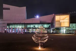 © Anja Koehler Eine Person zeichnet vor dem Festspielhaus Bregenz mit einer Wunderkerze die Silhouette eines Weihnachtsbaumes © Anja Koehler