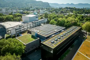 Drohnenaufnahme begrünter Dächer mit PV-Anlagen inmitten vieler Bäume © bobdo