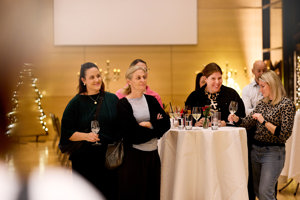 Eine Gruppe Frauen an einem Stehtisch amüsiert sich