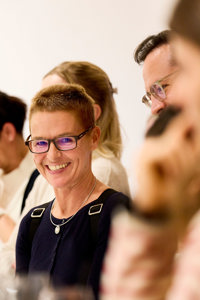 Eine Frau mit Brille lächelt in die Kamera